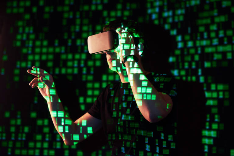 Double exposure of a caucasian man and Virtual reality headset is presumably a gamer or a hacker cracking the code into a secure network or server, with lines of code