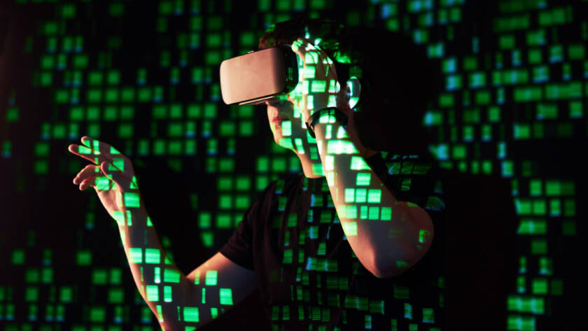 Double exposure of a caucasian man and Virtual reality headset is presumably a gamer or a hacker cracking the code into a secure network or server, with lines of code