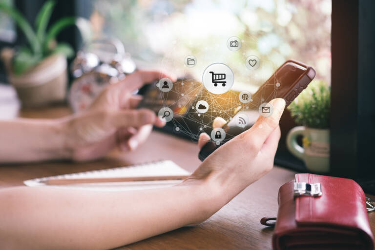 Close up of young woman use smart phone and holding credit card
